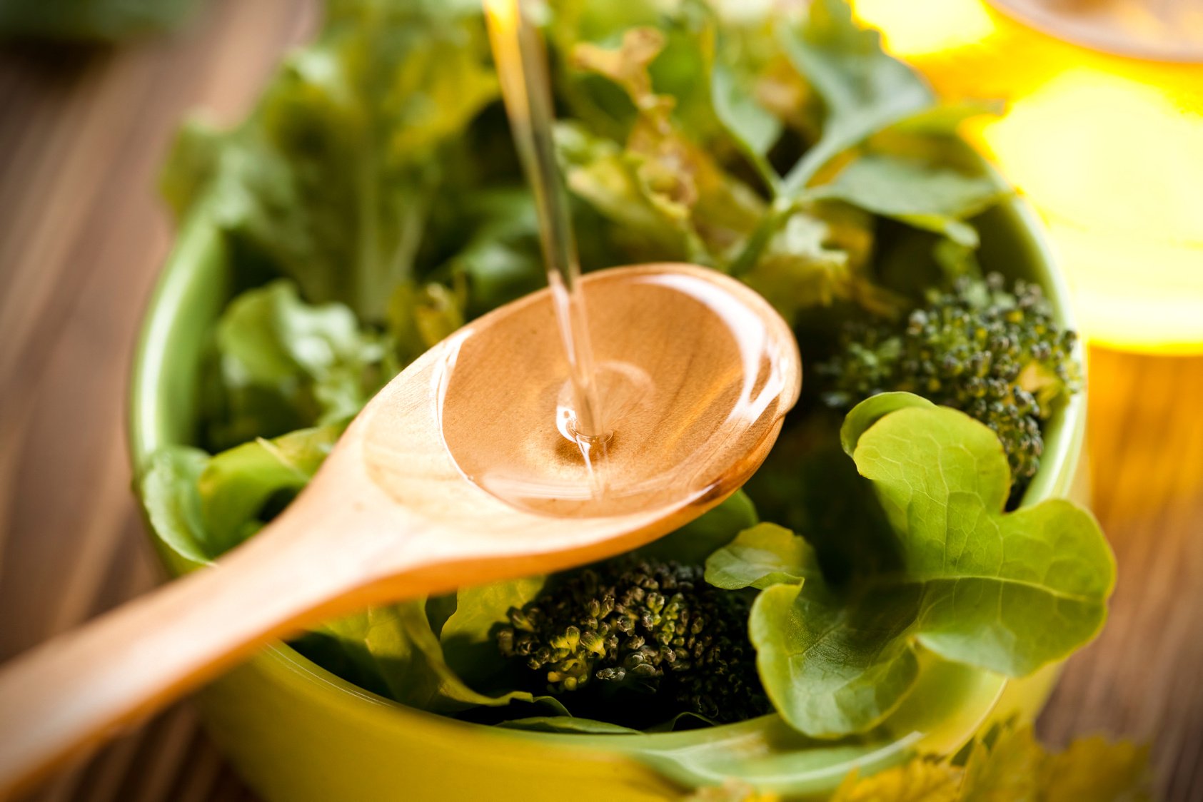 Pouring Olive Oil into Salad