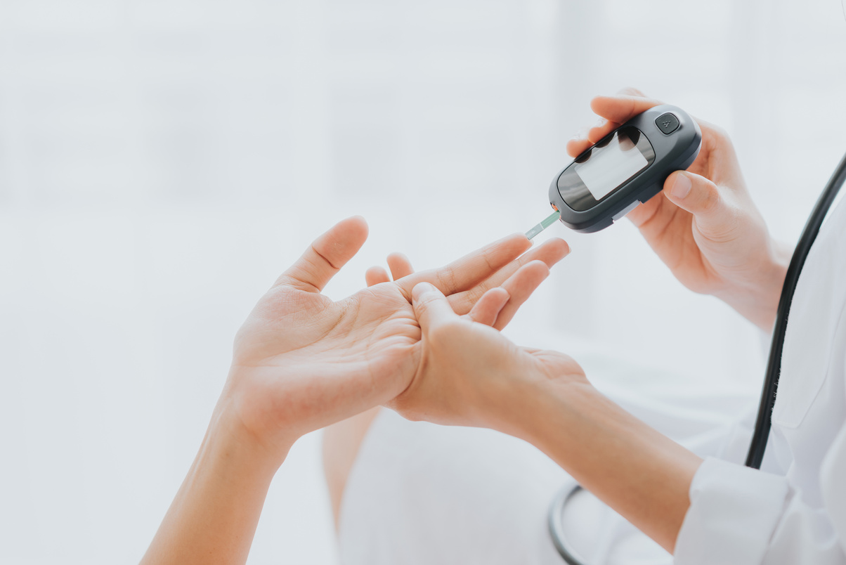 Doctor Use Glucometer Checking Blood Sugar Level From Patient Hand